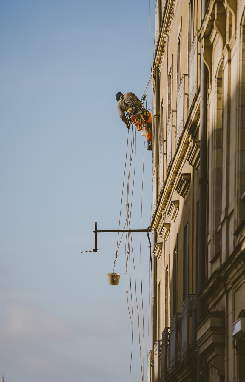 Cordiste soulevant un seau pour des travaux de maçonnerie à Nantes